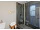 Bathroom featuring a glass-enclosed shower with gray tile, a gold coat rack, and a white toilet at 3401 N Steele St, Denver, CO 80205