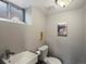Simple bathroom featuring a clean sink, toilet, and natural lighting from the basement window at 3401 N Steele St, Denver, CO 80205