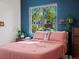 A cozy bedroom with a coral bed, natural lighting, and view to the exterior at 3401 N Steele St, Denver, CO 80205