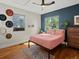 Bright bedroom features natural light, wood floors, an area rug and a coral colored bed at 3401 N Steele St, Denver, CO 80205