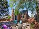 Charming brick home with inviting fire pit and colorful Adirondack chairs surrounded by mature trees at 3401 N Steele St, Denver, CO 80205