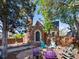 Charming brick home featuring a landscaped front yard with fire pit and colorful Adirondack chairs at 3401 N Steele St, Denver, CO 80205