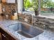 Granite countertops and a mosaic backsplash surround the stainless steel kitchen sink at 3401 N Steele St, Denver, CO 80205
