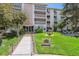 Inviting condo building exterior with manicured lawn and accessible ramp entrance at 3164 S Wheeling Way # 302, Aurora, CO 80014