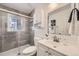 Updated bathroom with glass-enclosed shower, stylish tile, and vanity with ample storage at 3440 Chase St, Wheat Ridge, CO 80212