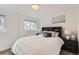 Comfortable bedroom with a queen-sized bed, dark furniture, and ample natural light from two windows at 3440 Chase St, Wheat Ridge, CO 80212