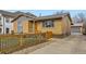 Inviting exterior of home features a modern fence, stone accents, and well-manicured landscaping at 3440 Chase St, Wheat Ridge, CO 80212