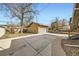 View of the detached one-car garage with a concrete driveway and yard at 3440 Chase St, Wheat Ridge, CO 80212