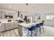 Bright kitchen with an island, modern appliances, and light gray cabinets and marbled backsplash at 3440 Chase St, Wheat Ridge, CO 80212