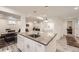 Open kitchen featuring a large island, stainless steel sink, and modern finishes connecting to dining and living spaces at 3440 Chase St, Wheat Ridge, CO 80212