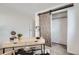 Home office with sliding barn door closet and desk, providing functional workspace at 3440 Chase St, Wheat Ridge, CO 80212