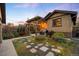 Landscaped backyard with stone pathway, dining area with pergola, and lush plants at 1918 S Lincoln St, Denver, CO 80210