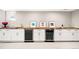 Basement bar with white cabinets, wood countertop, sink, wine cooler, beverage fridge and art at 1918 S Lincoln St, Denver, CO 80210