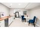 Sitting area with wet bar and table for two with blue chairs in finished basement at 1918 S Lincoln St, Denver, CO 80210