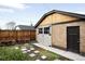 Detached brick garage with wooden siding, garden beds, and stone pathway at 1918 S Lincoln St, Denver, CO 80210