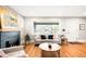 Spacious living room with hardwood floors, fireplace, and large window offering neighborhood views at 1918 S Lincoln St, Denver, CO 80210
