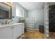 Well-lit bathroom with a modern vanity, glass block partition, and tiled shower at 7209 S Sherman St, Centennial, CO 80122