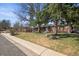 Lovely brick home boasts a spacious front yard with mature trees, enhancing curb appeal and shade at 7209 S Sherman St, Centennial, CO 80122