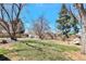 Large backyard with mature trees providing shade and a cozy outdoor seating area at 6707 S Elizabeth St, Centennial, CO 80122