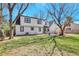 The back of the house shows a large lawn, a patio, a second story deck, and mature trees at 6707 S Elizabeth St, Centennial, CO 80122