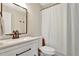 Bright bathroom features a white vanity with solid surface countertop, and a shower with curtain rod at 6707 S Elizabeth St, Centennial, CO 80122