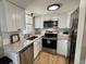 Updated kitchen featuring stainless steel appliances, granite countertops, and white cabinetry at 6895 W 84Th Way # 4, Arvada, CO 80003