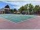 Well-maintained tennis court with a green playing surface and sturdy net, surrounded by trees and nearby townhomes at 6895 W 84Th Way # 4, Arvada, CO 80003