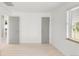 Minimalist bedroom features two gray doors, one window, and light hardwood floors at 5090 W 36Th Ave, Denver, CO 80212