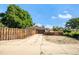 Charming home exterior with a long driveway, garage, wooden fence, and a large shade tree at 5090 W 36Th Ave, Denver, CO 80212