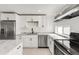 Modern kitchen with stainless steel appliances, white cabinets, and white marble countertops at 5090 W 36Th Ave, Denver, CO 80212