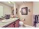 Charming powder room featuring a vanity with a sink, toilet, decorative mirror, and artwork at 529 Gallegos Cir, Erie, CO 80516