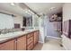 Bathroom with double sinks, vanity, and a glass-enclosed shower featuring tile accents at 529 Gallegos Cir, Erie, CO 80516