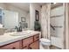 Bathroom with wood vanity, tile accents and shower over tub at 529 Gallegos Cir, Erie, CO 80516