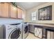 Well-equipped laundry room with front-load washer and dryer, storage cabinets, and countertop space at 529 Gallegos Cir, Erie, CO 80516