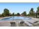 Large community pool surrounded by lounge chairs and lush green trees at 529 Gallegos Cir, Erie, CO 80516