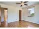 Bedroom with hardwood floors, neutral walls, ceiling fan, and view into adjacent room at 1523 Ivy St # 6, Denver, CO 80220
