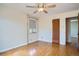 Bedroom featuring hardwood floors, neutral walls, ceiling fan, and view into hallway at 1523 Ivy St # 6, Denver, CO 80220