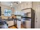 Functional kitchen with stainless steel refrigerator, gas range, black countertop, and window at 1523 Ivy St # 6, Denver, CO 80220