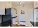Efficient kitchen with stainless steel refrigerator, black countertops, and natural light from window at 1523 Ivy St # 6, Denver, CO 80220
