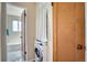 Laundry area with washer/dryer and view into updated bathroom with white subway tiles at 1523 Ivy St # 6, Denver, CO 80220