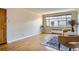 Sunny living room with hardwood floors, large window, neutral paint, and comfortable chair at 1523 Ivy St # 6, Denver, CO 80220