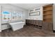 This bathroom features a modern soaking tub, double sink vanity, and wood-look tile floors at 449 Dunmire St, Frederick, CO 80530