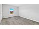 Bright bedroom features plush gray carpet, light gray walls, and a window with scenic views at 449 Dunmire St, Frederick, CO 80530