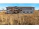 Exterior rear view of a house with a balcony and stairs leading to the backyard at 449 Dunmire St, Frederick, CO 80530