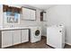 Well-equipped laundry room features a sink, wood-look flooring, washer and dryer at 449 Dunmire St, Frederick, CO 80530
