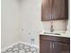 Laundry room with stylish tile floors, upper cabinets, and a sink, offering both beauty and functionality at 483 Basin Daisy St, Castle Rock, CO 80104