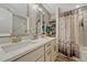 Bright bathroom featuring double sinks, a large mirror, and a shower with a decorative curtain at 25694 Stansbery St, Conifer, CO 80433