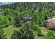 Aerial view of the home surrounded by lush greenery and a wooded landscape at 25694 Stansbery St, Conifer, CO 80433