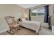 Relaxing bedroom with a rocking chair next to a large window at 25694 Stansbery St, Conifer, CO 80433
