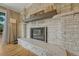 Modern fireplace featuring stone surround, wooden mantle and hardwood floors at 25694 Stansbery St, Conifer, CO 80433